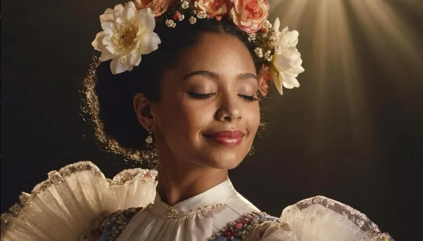 A vibrant digital portrait of a smiling woman with her eyes closed, wearing a lush crown of colorful roses and flowers against a warm background.